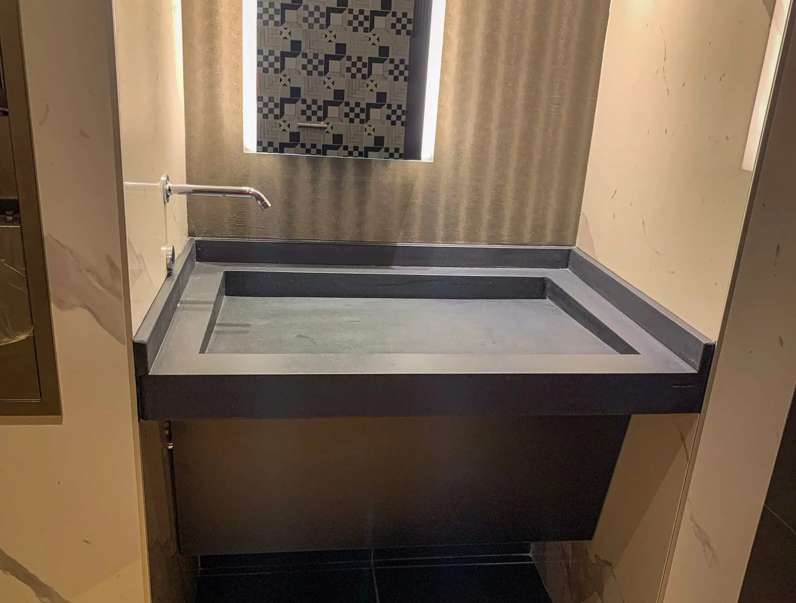 Custom cast concrete sink and countertop assembly installed within a commercial kitchen or service area.