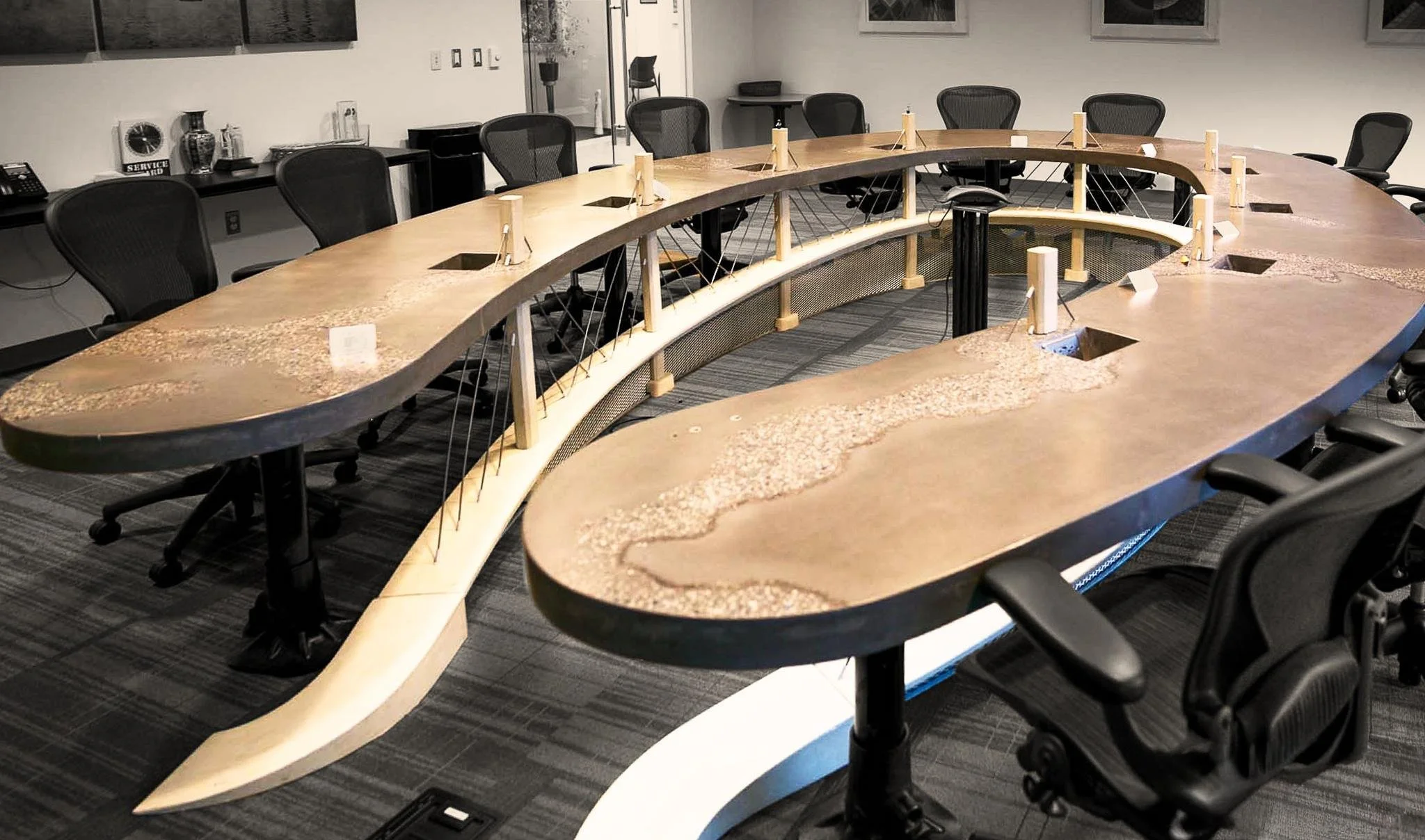 Custom sculptural concrete executive table with integrated topographic relief and flowing form, designed and fabricated by The Concrete Anomaly for Structural Group headquarters.