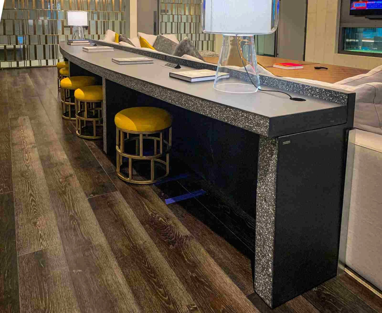 Hand-cast concrete turnkey desk with integrated returns and exposed aggregate finish, fabricated by The Concrete Anomaly and shown in installed condition.
