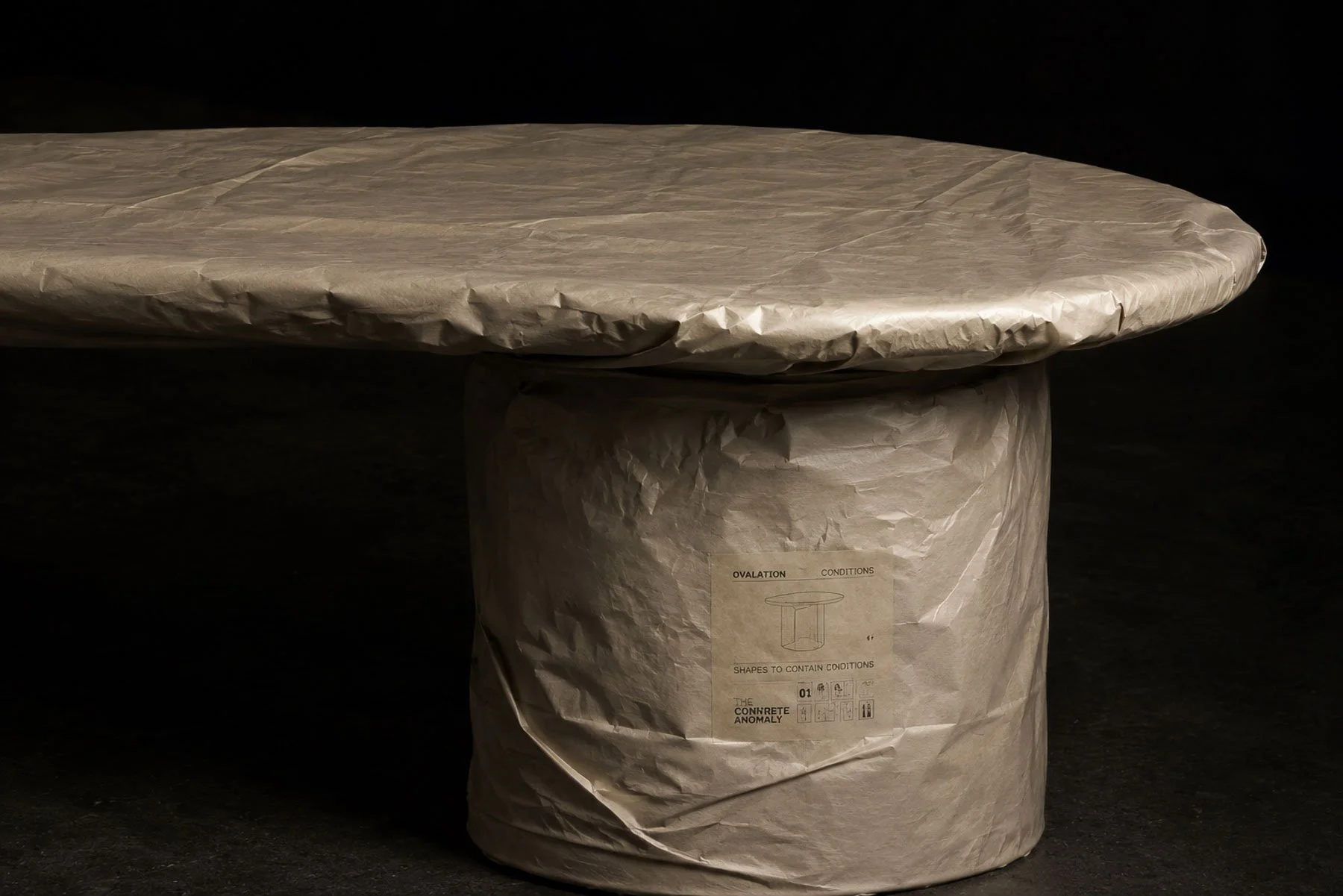 Close-up of the paper-wrapped OVALATION | ONE coffee table, illustrating THE PROGRAM concept where each piece evolves before final production.