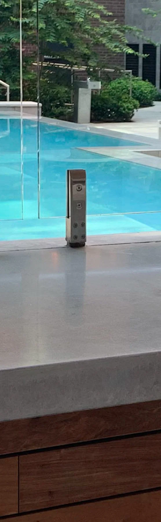 Installed architectural concrete surface adjacent to rooftop pool demonstrating the relationship between concrete, water, and reflected light.