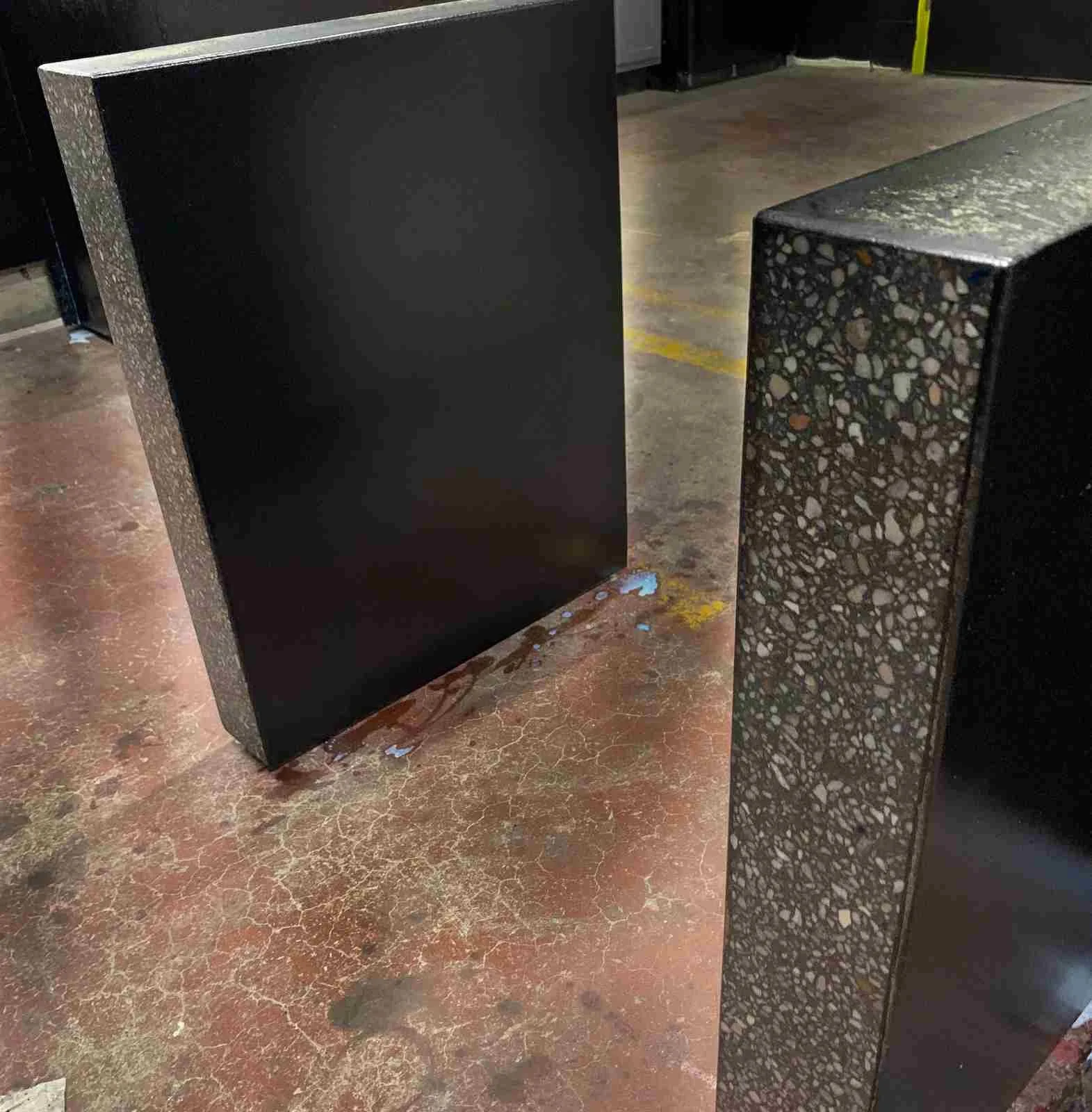 Fabricated sections of a custom turnkey concrete desk with honed surface and integrated returns, shown during shop staging by The Concrete Anomaly.