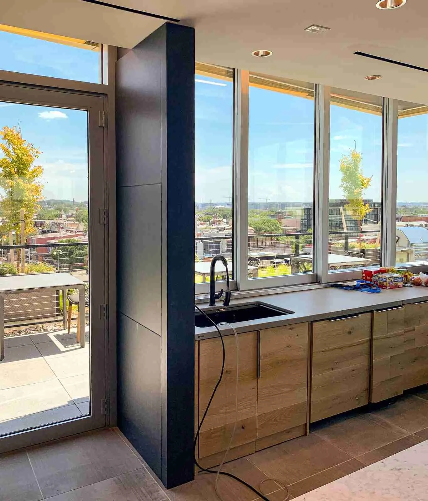 Custom cast concrete kitchen counter and sink installation positioned along a window wall in a modern interior.