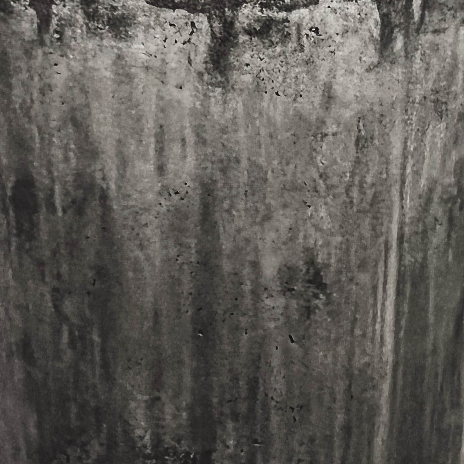 Dark monochromatic concrete texture with vertical mineral streaking, atmospheric tonal movement, and exposed pore structure from the line RAW series by The Concrete Anomaly