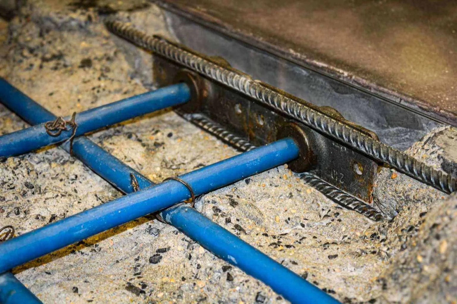 Detail view of reinforced concrete with embedded services and steel reinforcement, fabricated and coordinated by The Concrete Anomaly for a Structural Group interior buildout.