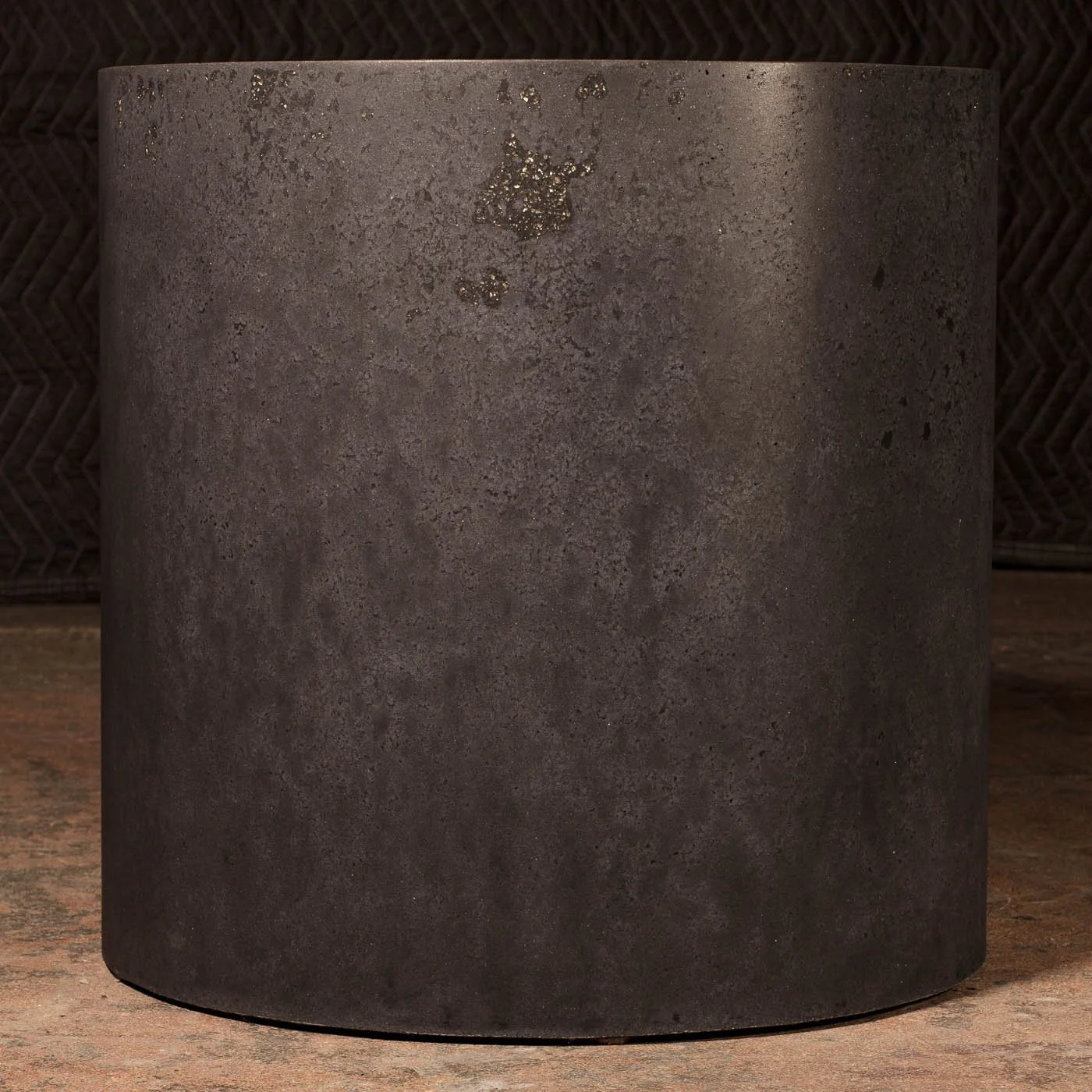 Dark atmospheric concrete side table from Line ZERO by The Concrete Anomaly with softened mineral texture and monolithic cylindrical form