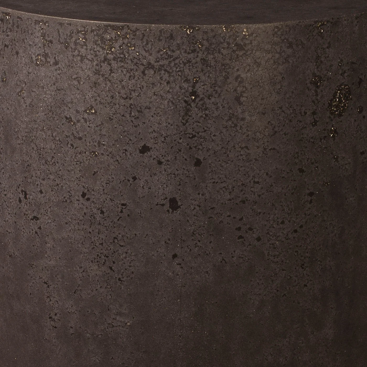Close-up detail of dark atmospheric concrete surface with dispersed mineral speckling and layered tonal movement