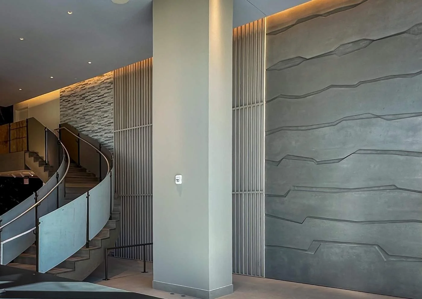 Architectural interior featuring custom cast concrete wall panels with continuous texture and integrated lighting.