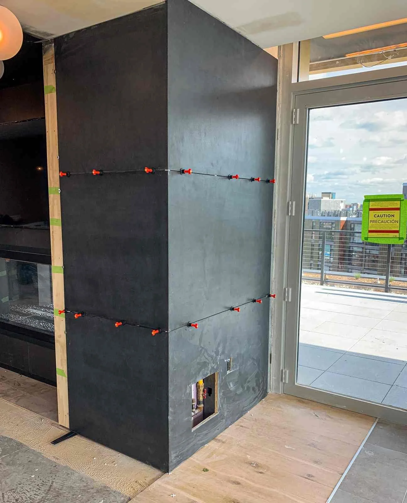 Custom cast concrete wall panel installation in progress, showing alignment and attachment within a modern interior.