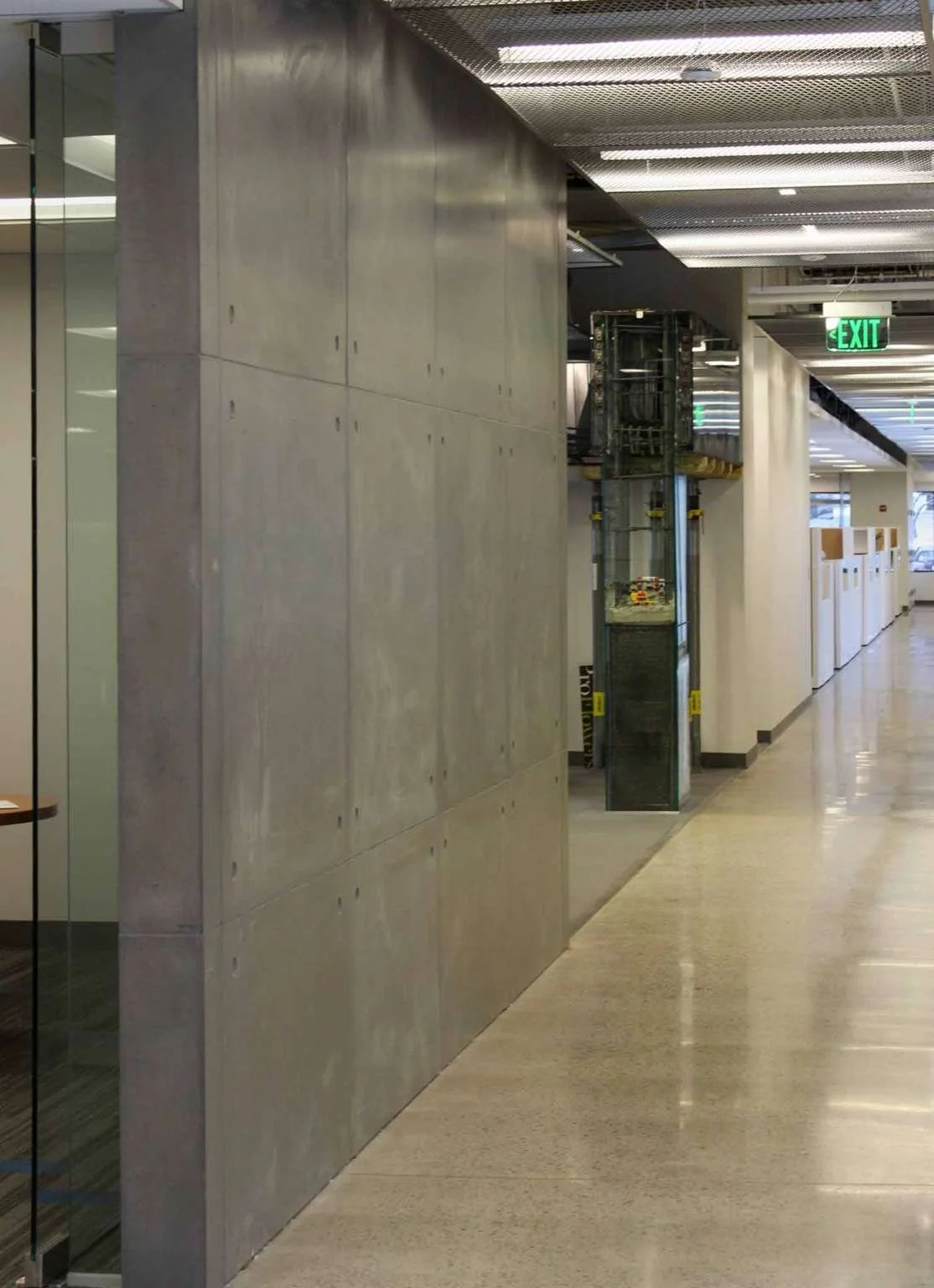 Installed architectural concrete wall panels forming a corridor condition, fabricated by The Concrete Anomaly for Structural Group headquarters.