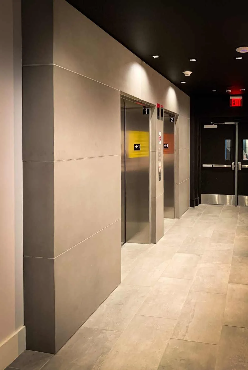 Custom cast concrete wall wraps and elevator surrounds installed within a commercial building interior.