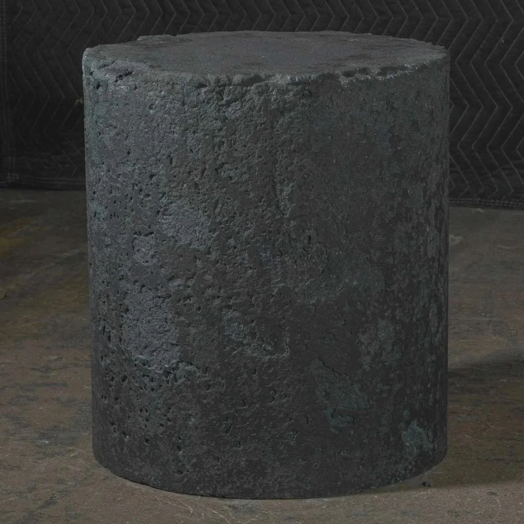 Dark textured concrete side table with heavily distressed volcanic-inspired surface by Dylan Myers from the line DEGRADATION series.