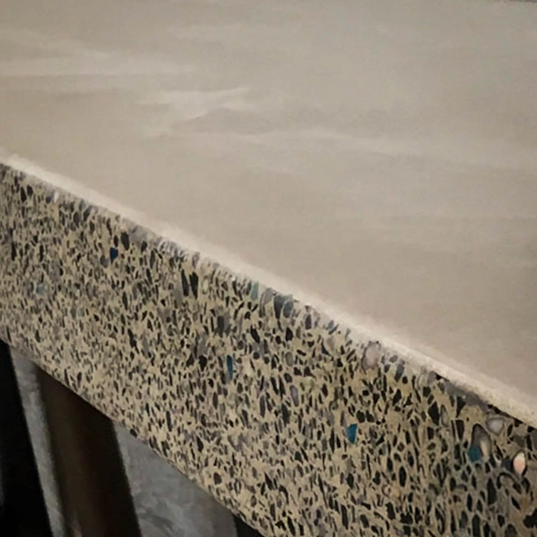 Edge detail of custom terrazzo concrete showcasing exposed aggregate and honed finish by The Concrete Anomaly.