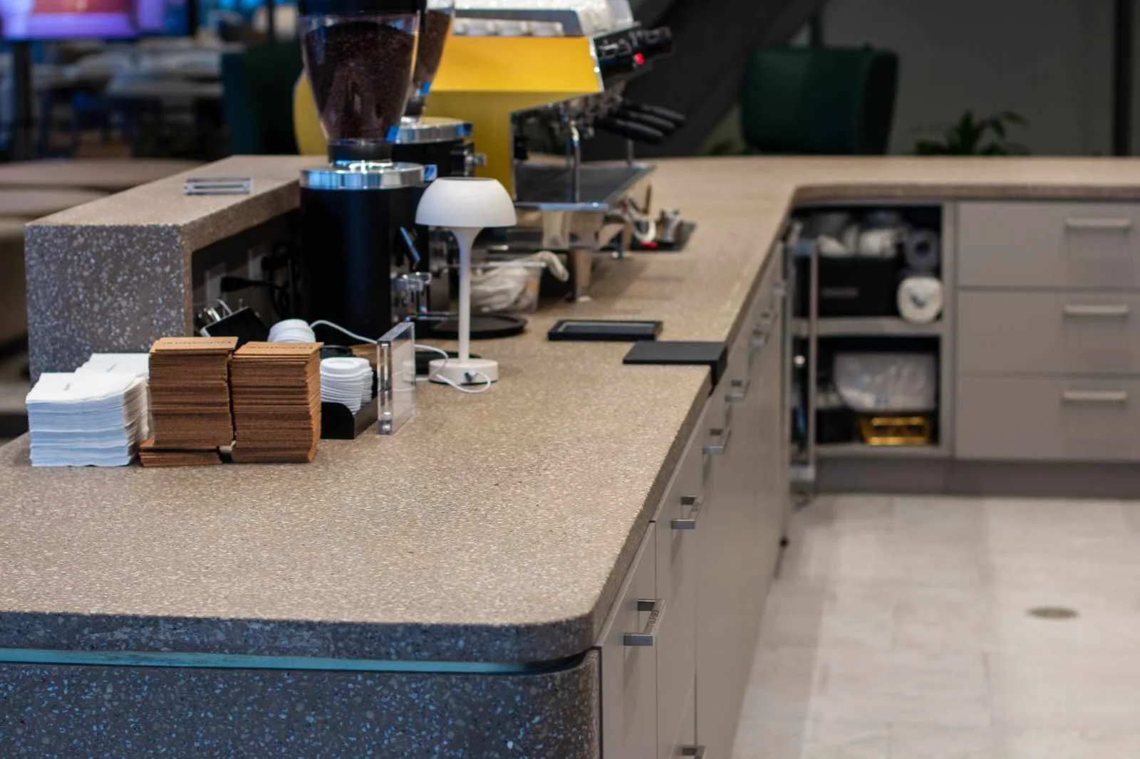 Custom cast concrete coffee counter with integrated aggregate surface, fabricated as a monolithic architectural element within a commercial interior.