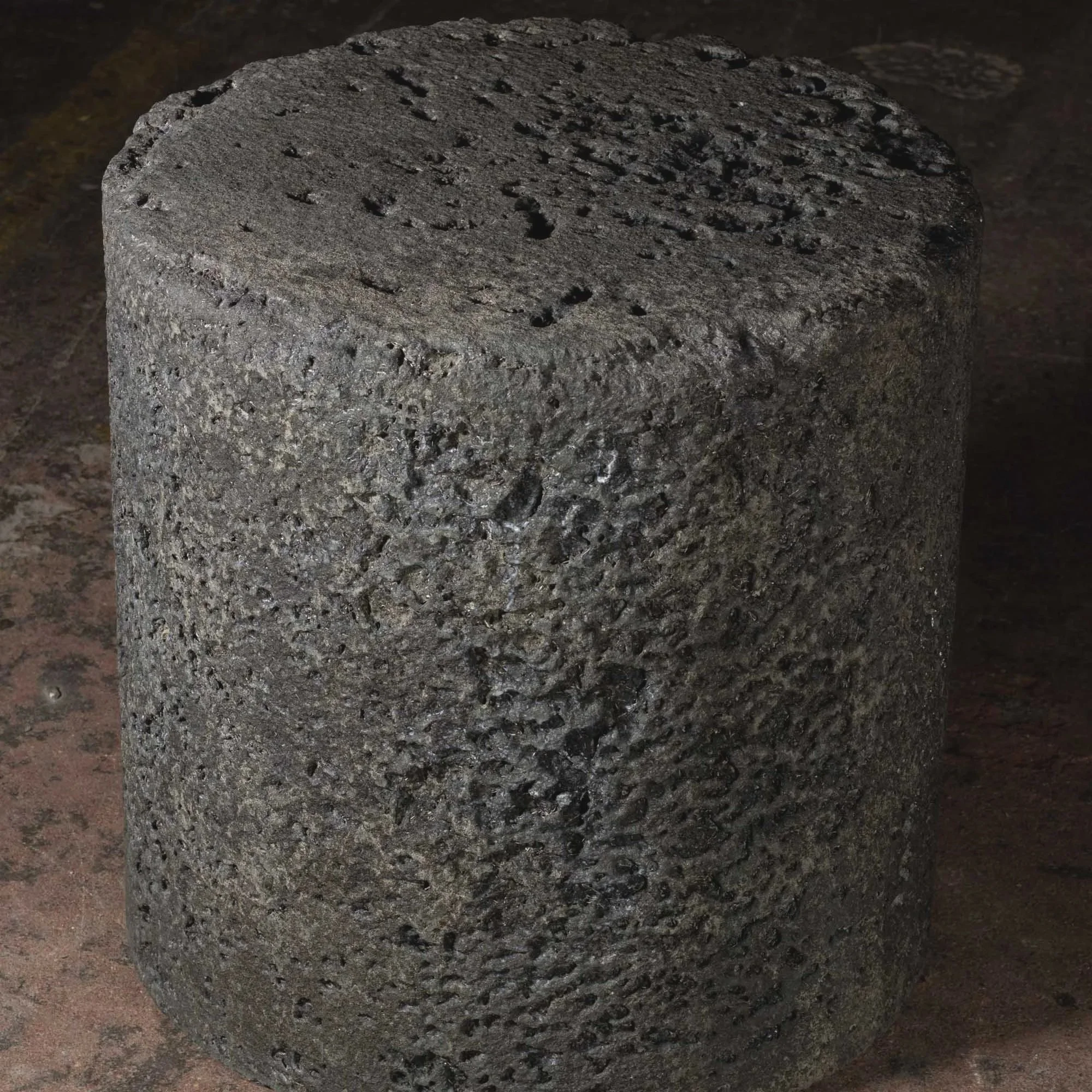 Hand-cast GFRC concrete cylinder featuring porous lava-inspired texture, atmospheric depth, and sculptural blackened finish from The Concrete Anomaly.