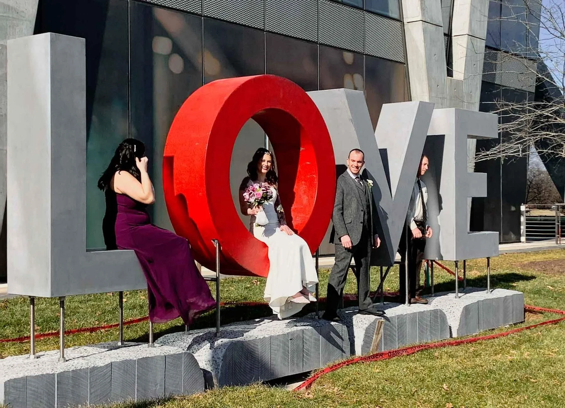 Visitors interacting with the monumental LOVE concrete sculpture installation at Reston Station.