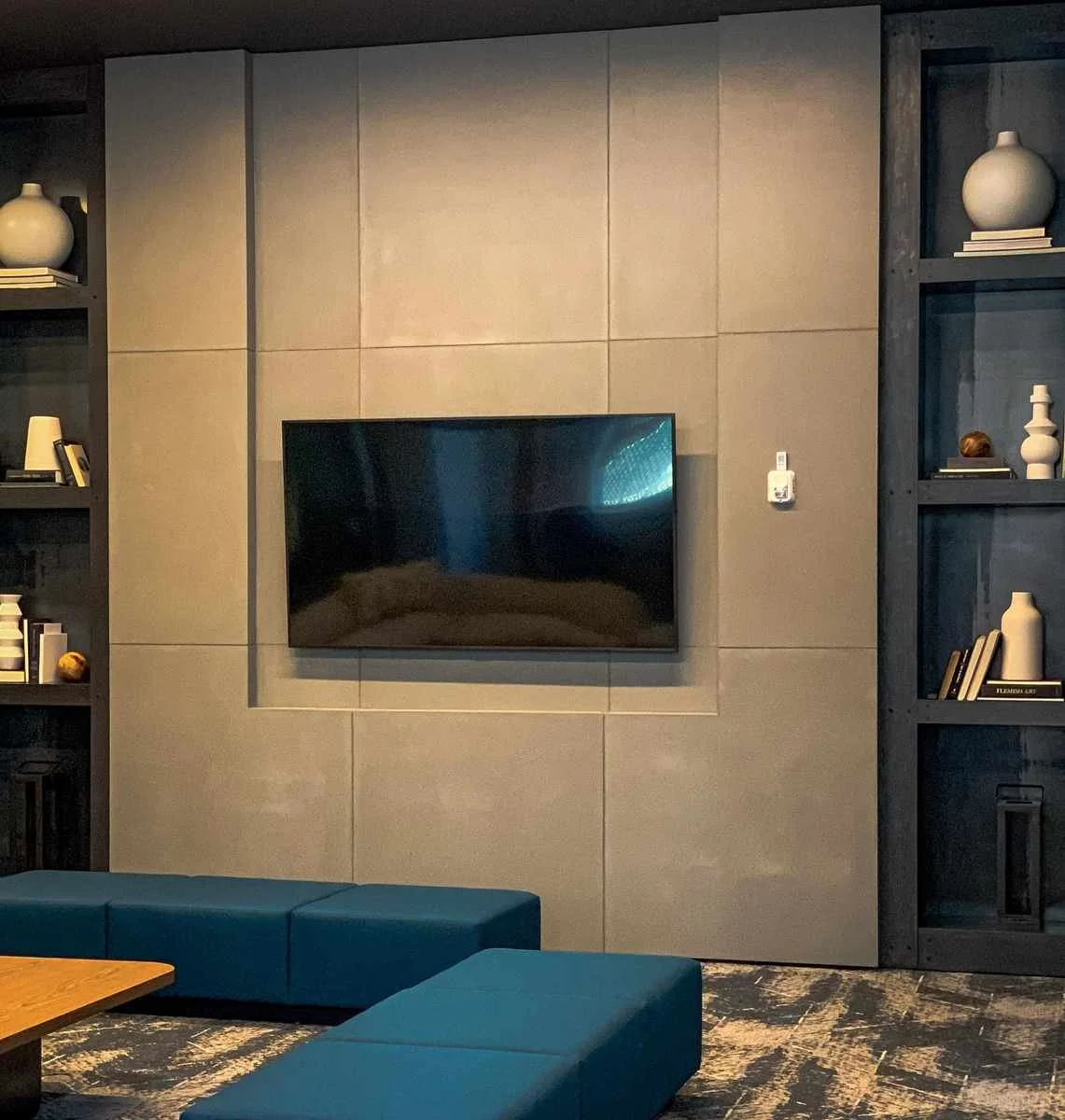 Custom cast concrete fireplace surround and wall panels forming the focal wall of a contemporary living space.