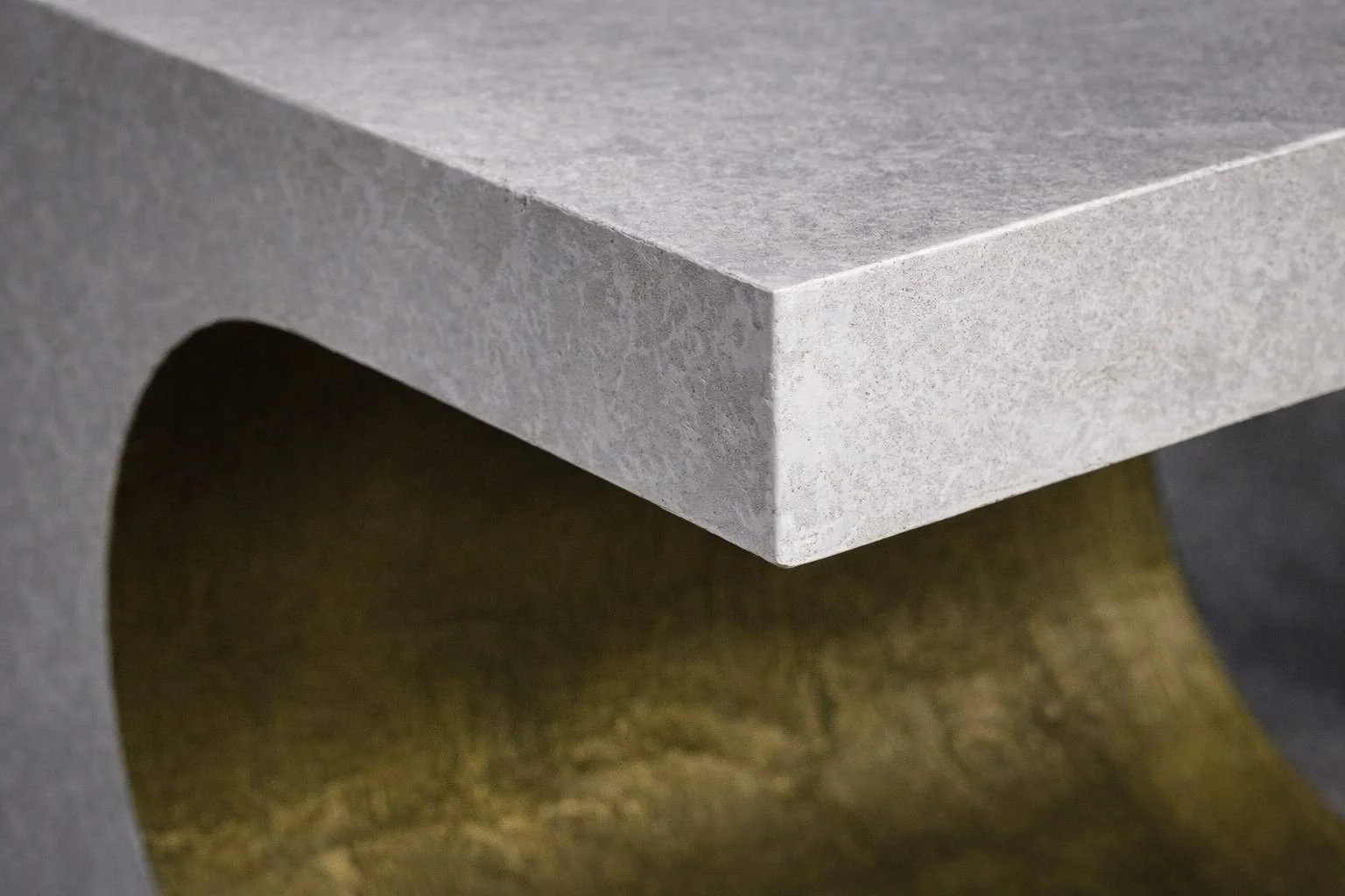 Close-up detail of a sculptural GFRC concrete table by The Concrete Anomaly showing refined edge geometry and monolithic surface texture.