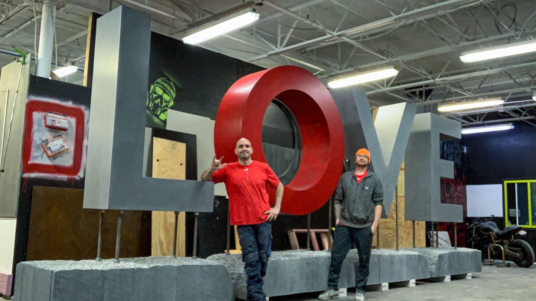 Two members of The Concrete Anomaly team with the monumental concrete LOVE sculpture during studio fabrication.