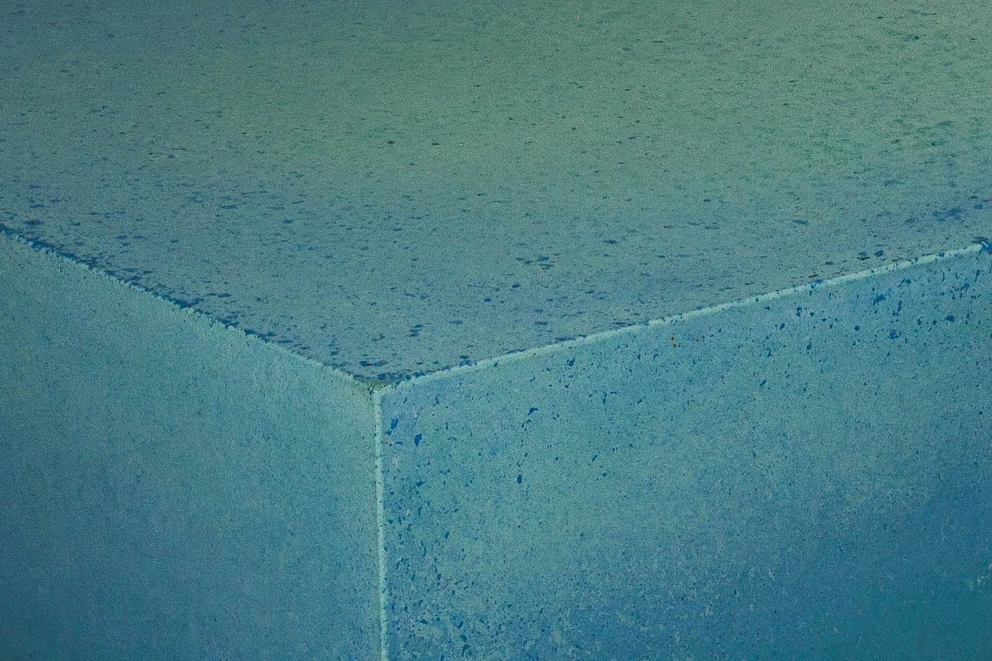 Chunk of Turquoise concrete artifact showing mineral pigment gradients and monolithic corner detail — The Concrete Anomaly.