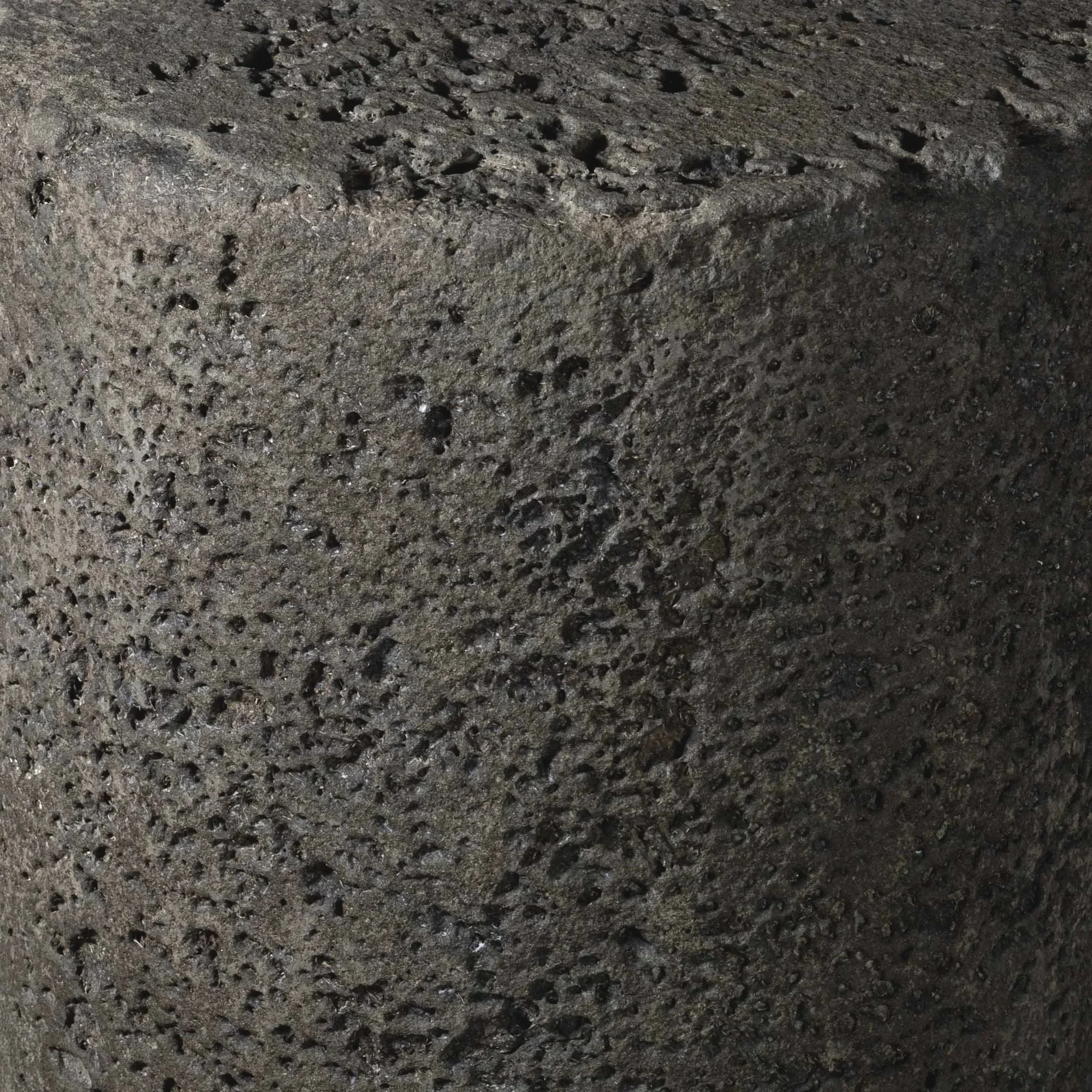 Close-up detail of Blued Lava concrete surface revealing cratered volcanic texture, mineral pitting, and eroded tactile character.