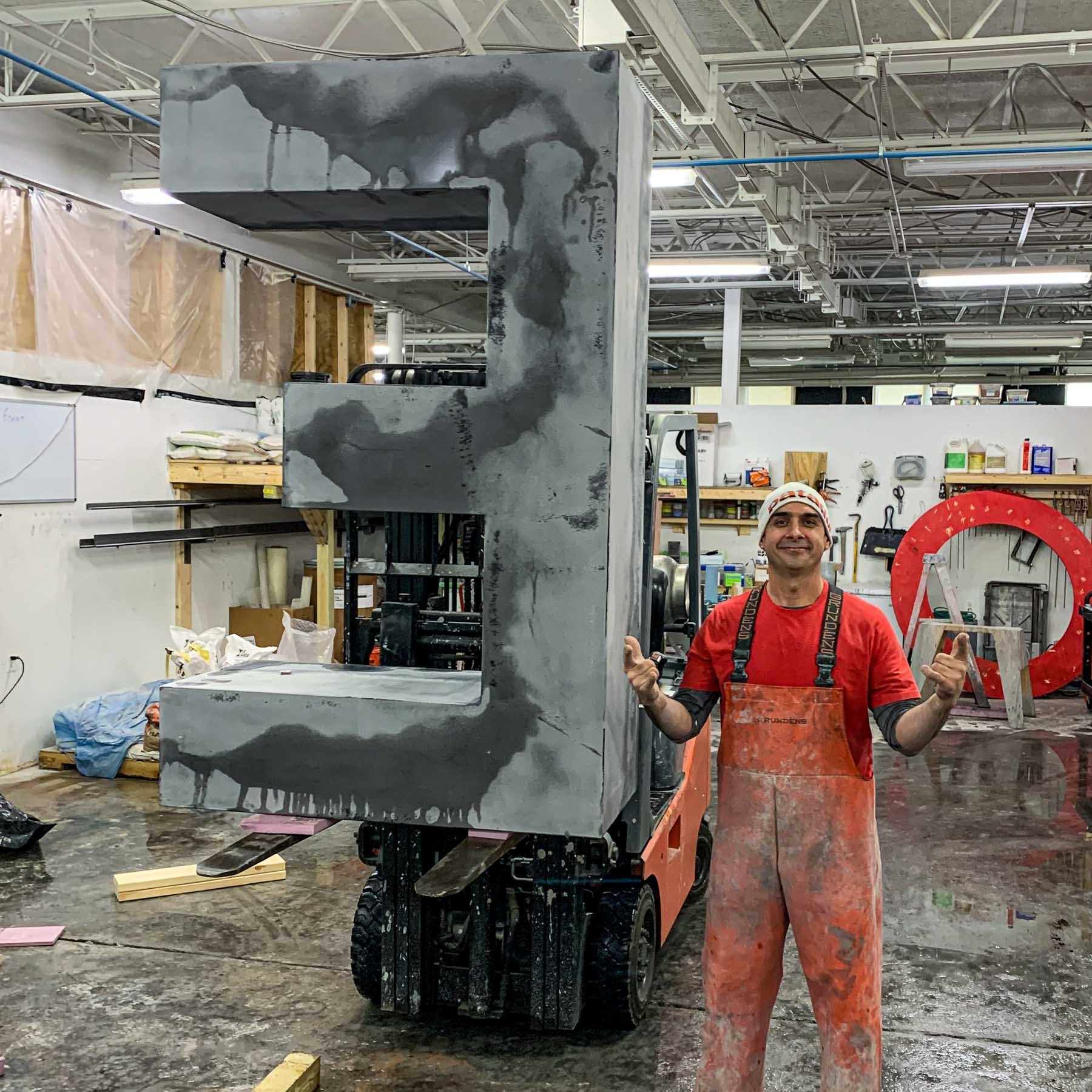 A Concrete Anomaly artisan beside a freshly cast LOVE sculpture component in the Maryland studio.