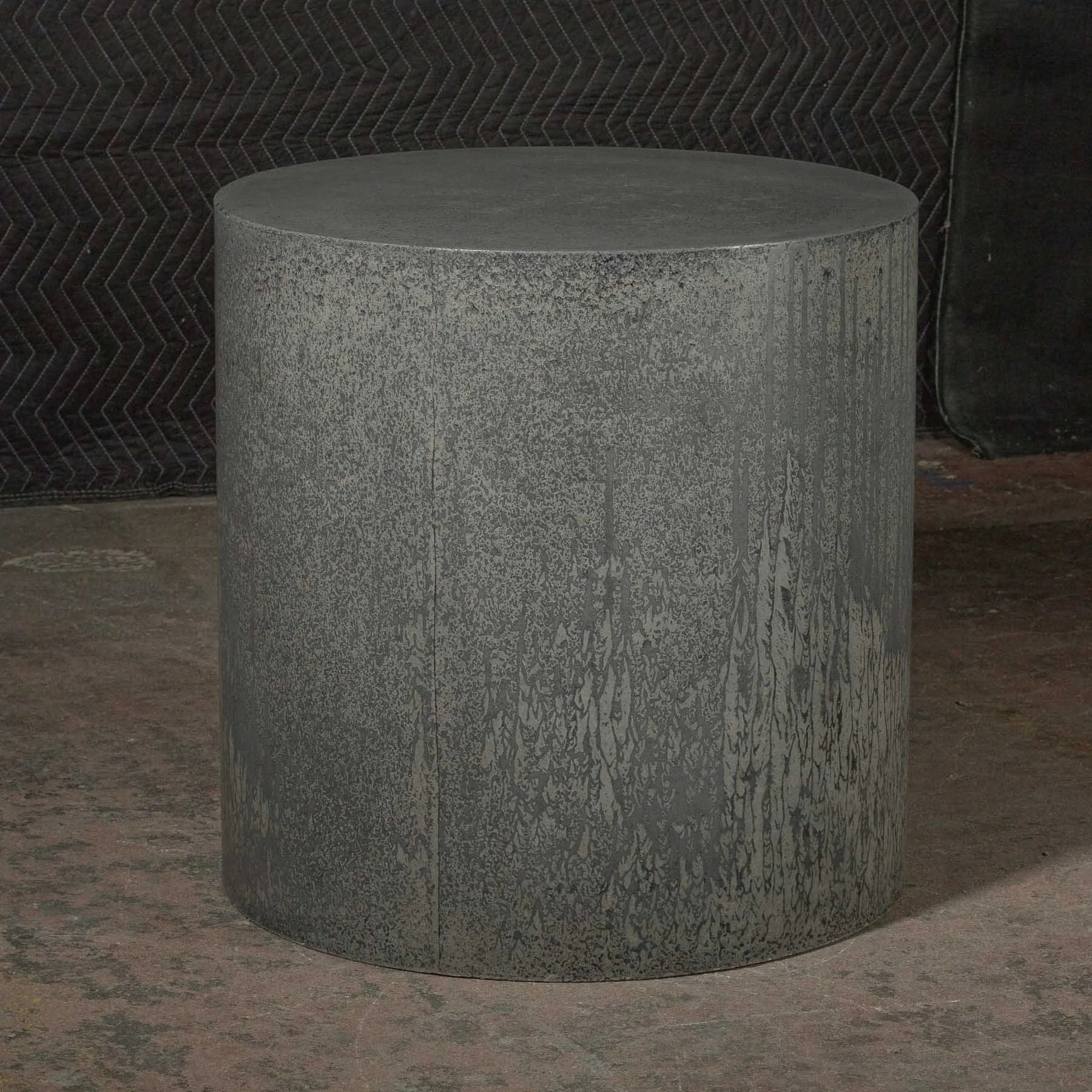 Hand-cast GFRC concrete cylinder showing organic downward pigment movement and layered surface variation from The Concrete Anomaly.
