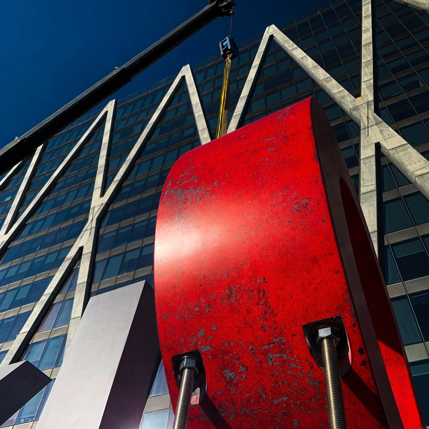 Low-angle view of the monumental LOVE concrete sculpture installation against the Reston Station skyline.