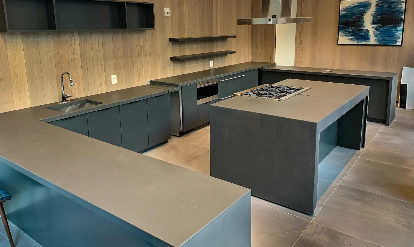 Integrated monolithic architectural concrete kitchen and waterfall island system fabricated by The Concrete Anomaly for a residential project in Loudoun County, Virginia.