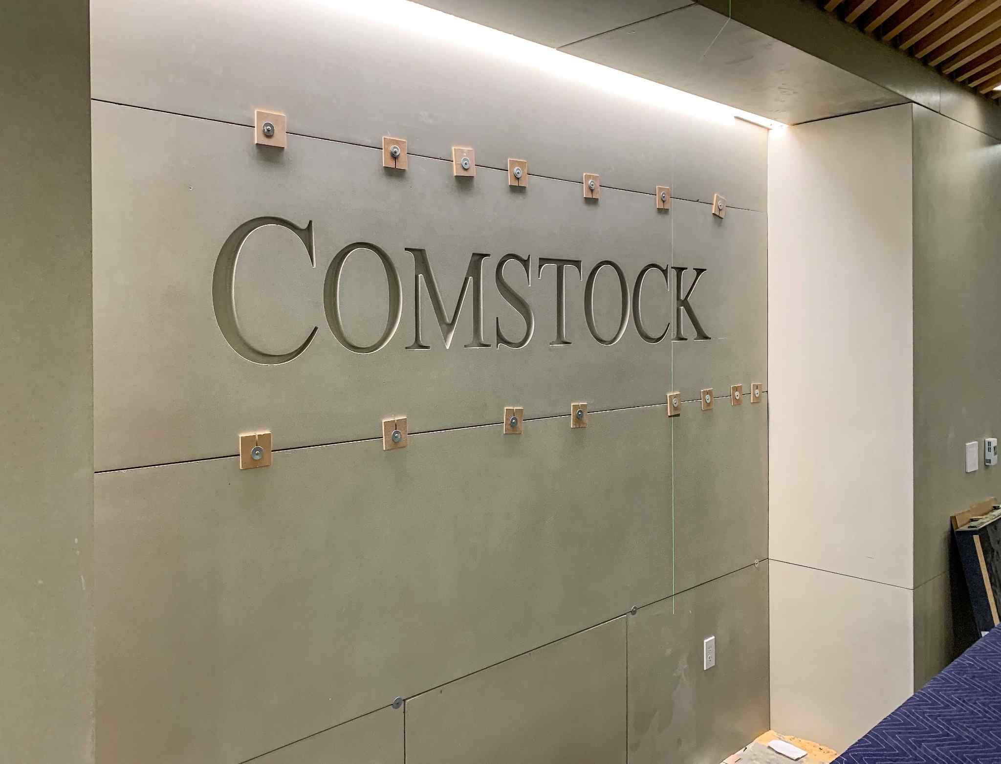 Custom concrete wall panels with integrated recessed lettering for corporate interior signage