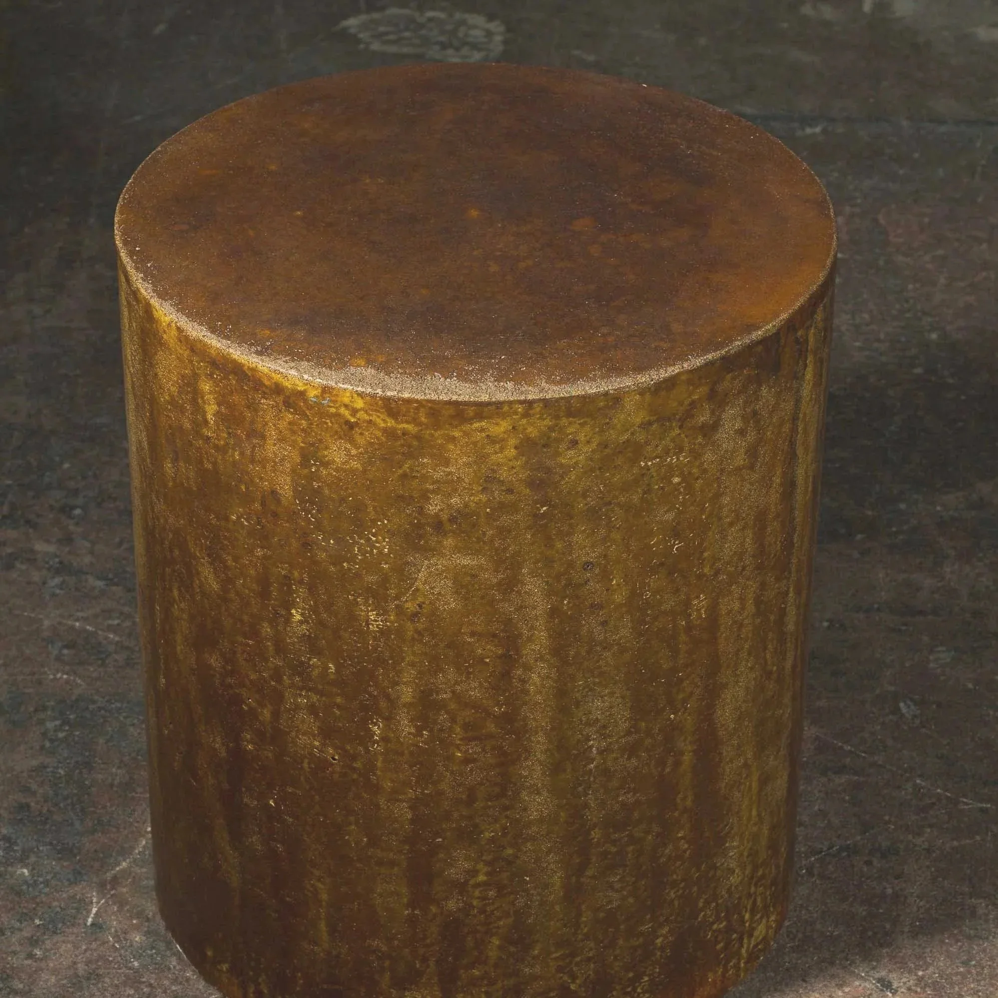 Concrete pedestal side table with oxidized metallic surface, layered pigment movement, and aged steel character inspired by industrial decay.