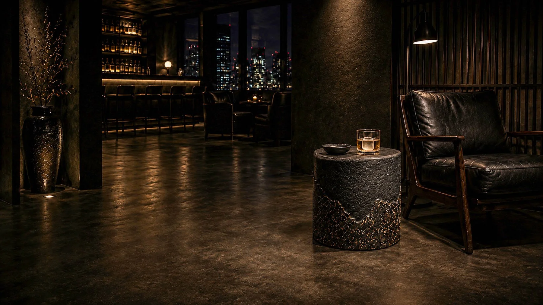 Concrete cylindrical side table with a fractured terrazzo condition positioned beside a leather lounge chair within a moody contemporary nightclub interior.