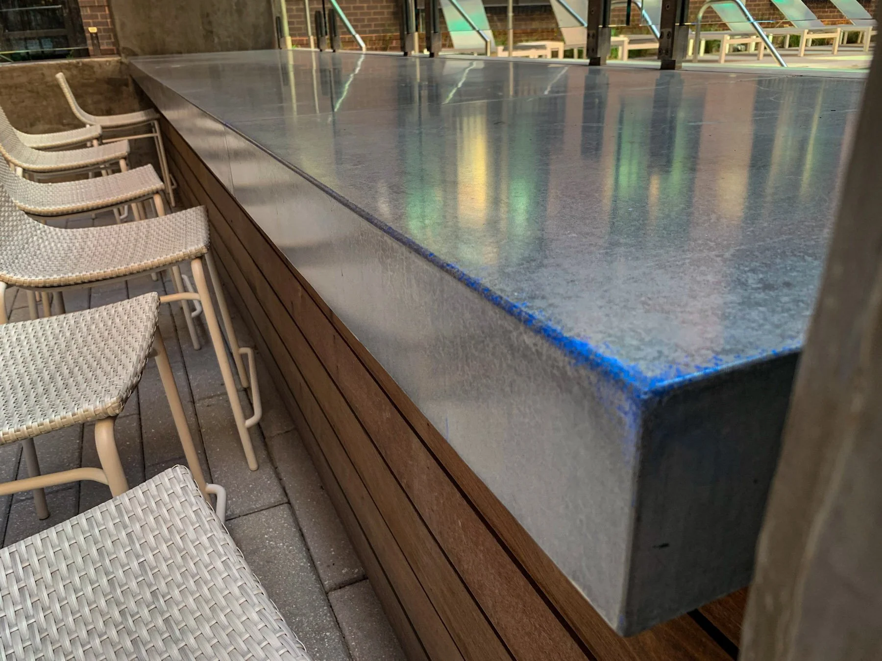 Honed salt and pepper concrete bar surface with integrated electric blue mineral condition developed for rooftop hospitality installation.