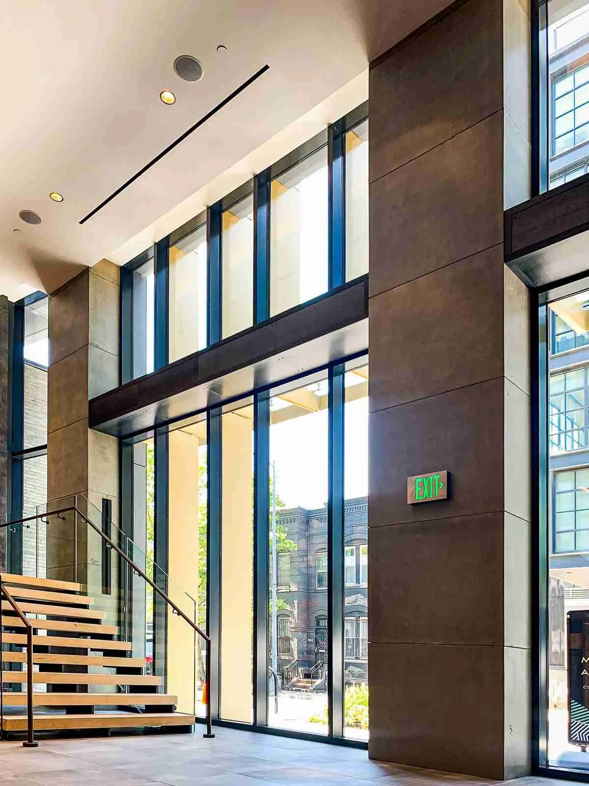 Custom cast concrete column wraps integrated within a modern architectural interior with glass and wood stair elements.