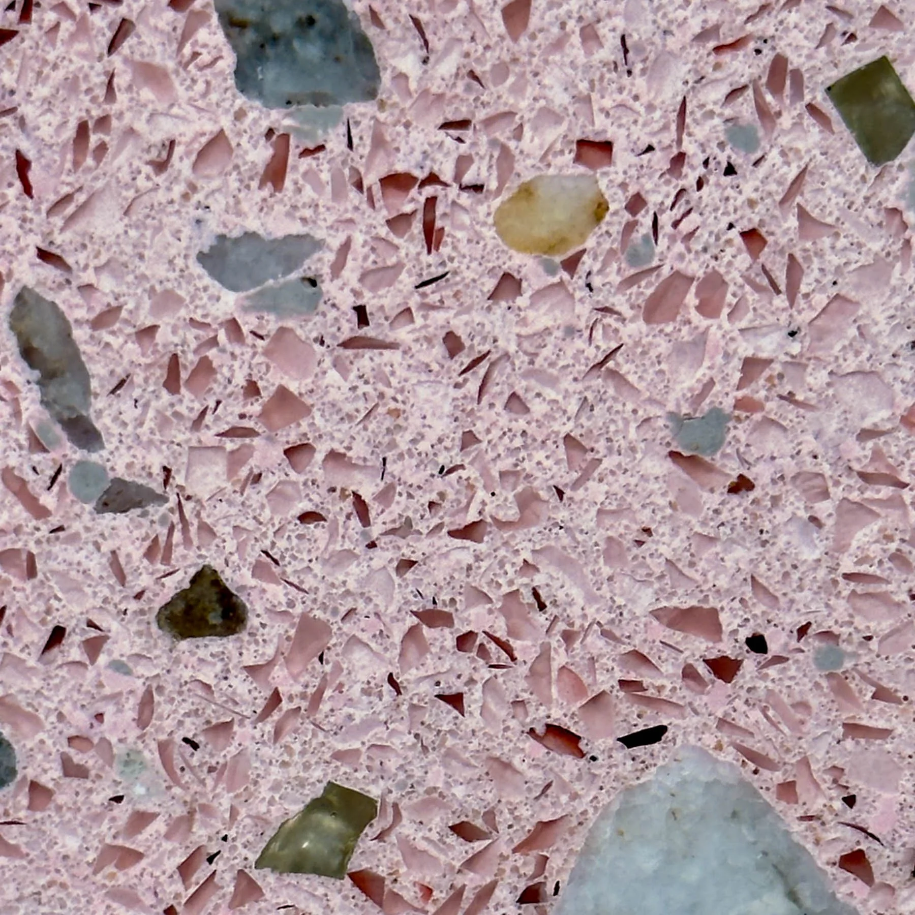 Close-up of pink terrazzo concrete with colorful exposed aggregate and integrated mineral fragments by The Concrete Anomaly.