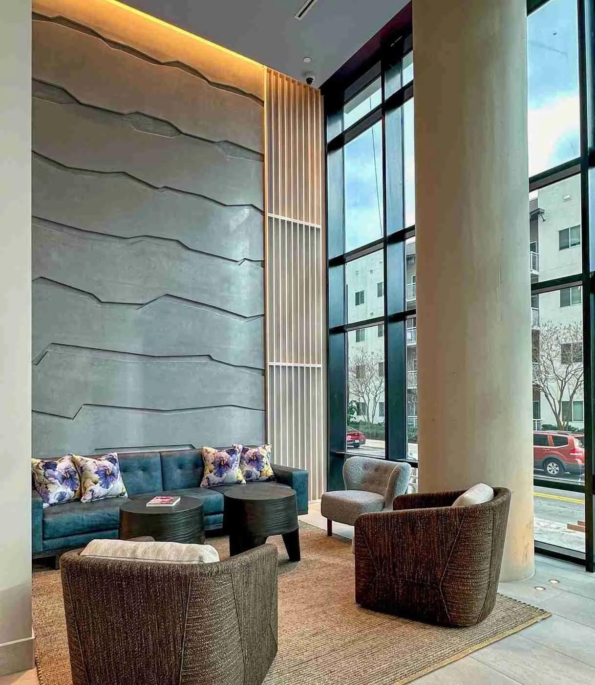 Architectural interior featuring custom cast concrete wall panels as a textured backdrop within a hotel lobby seating area.
