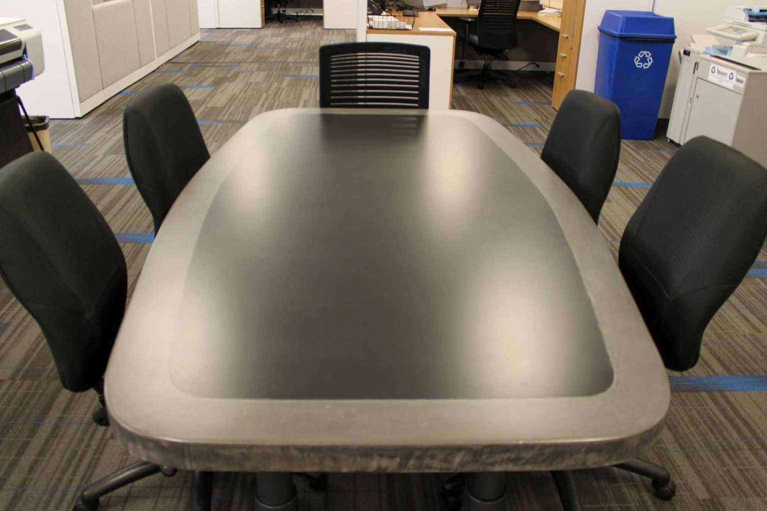Custom concrete executive conference table with soft-radius corners and monolithic form, designed and fabricated by The Concrete Anomaly for Structural Group.