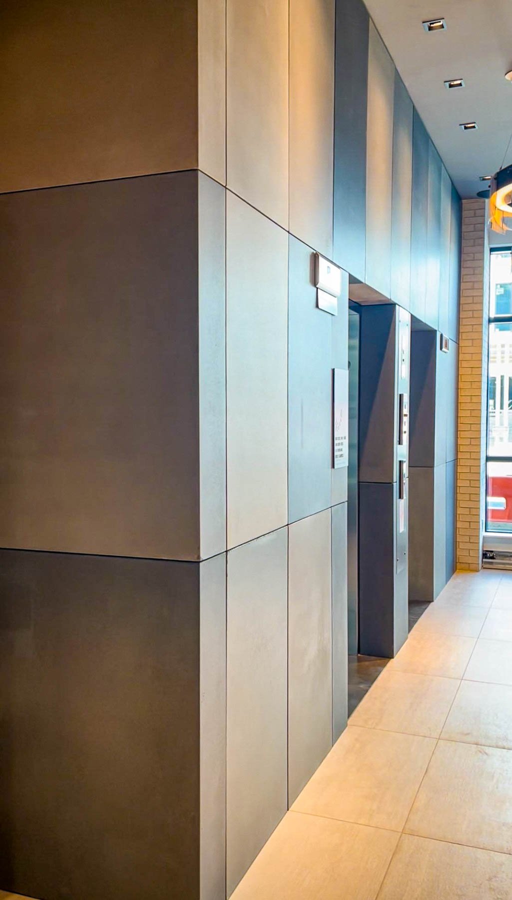 Architectural concrete elevator surrounds with monolithic corner conditions and custom thin-shell wall panels in a commercial lobby.
