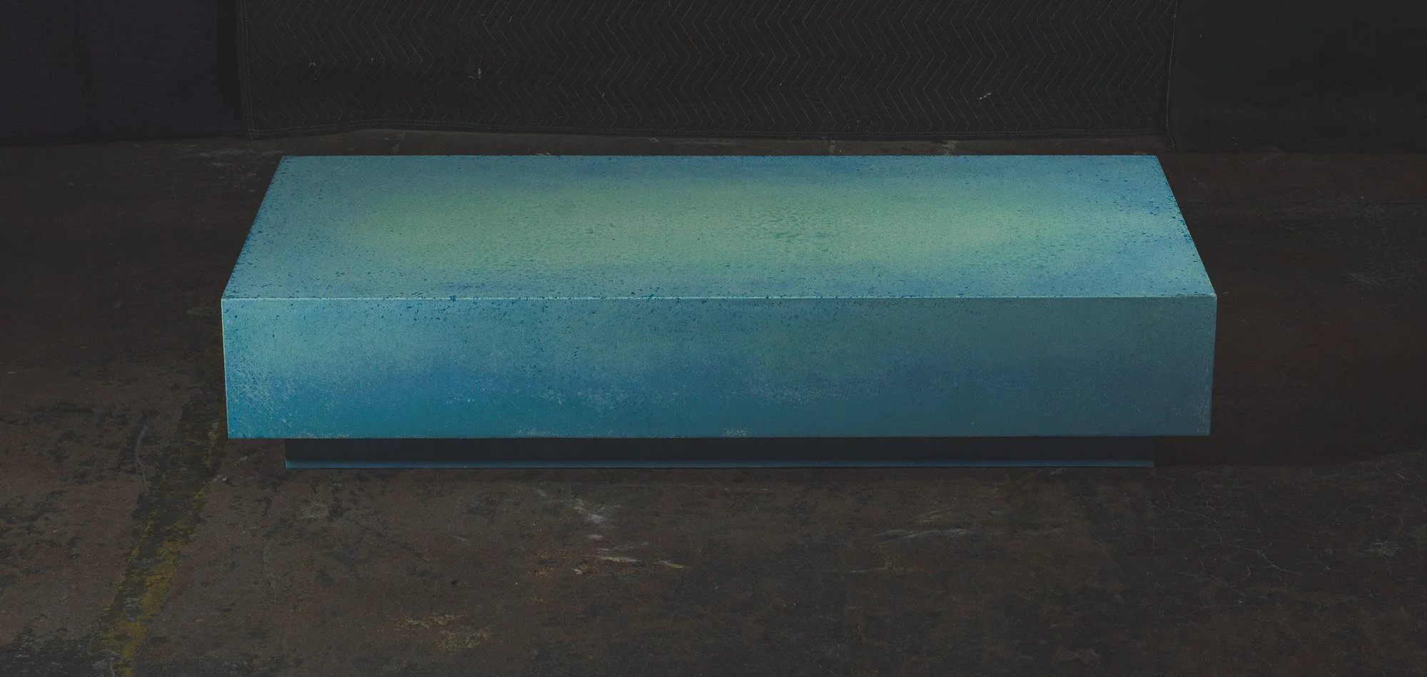 Chunk of Turquoise low-profile concrete coffee table with saturated turquoise mineral finish and monolithic sculptural form — collectible concrete furniture by The Concrete Anomaly.