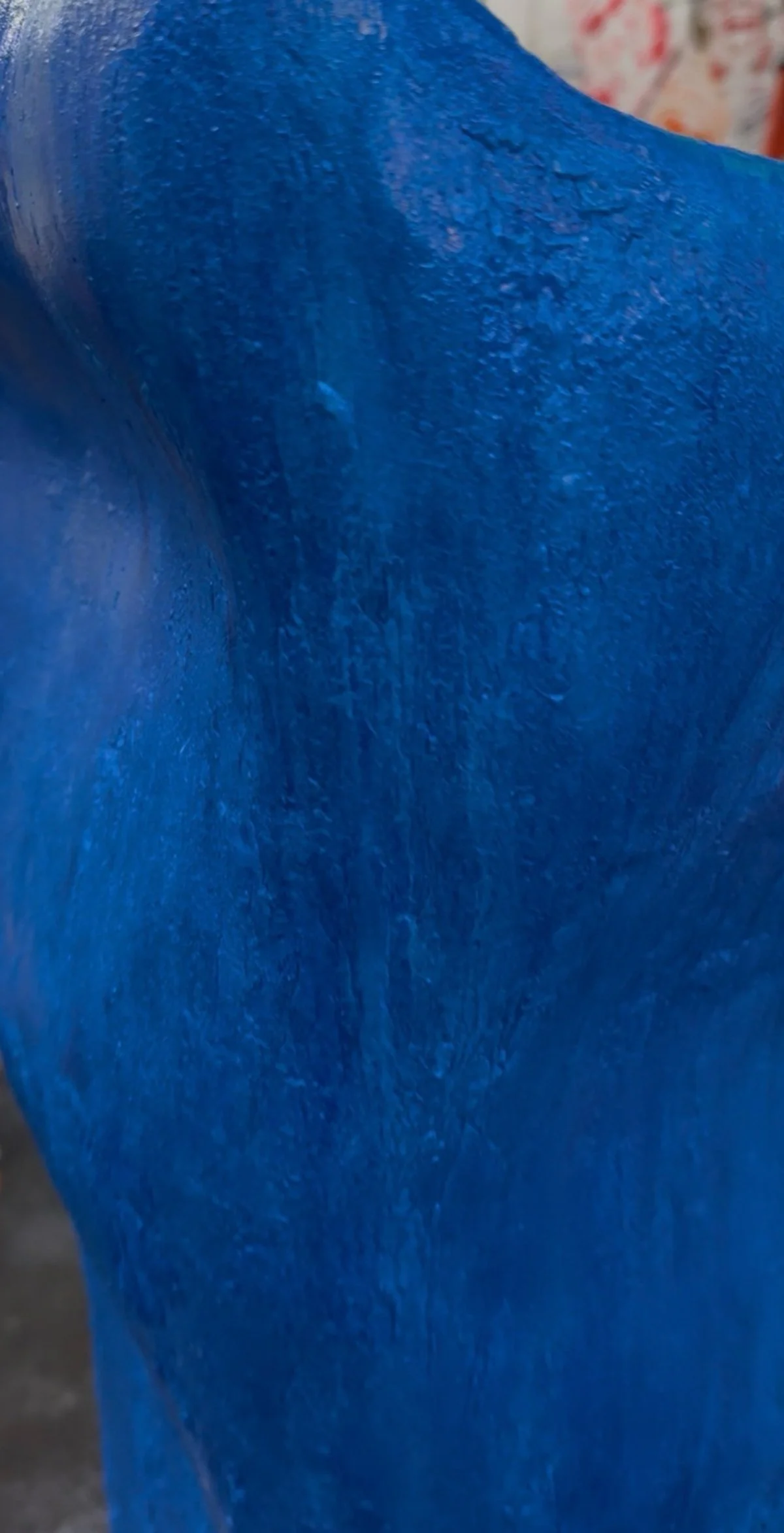 Close-up of a textured blue surface with visible brush strokes.