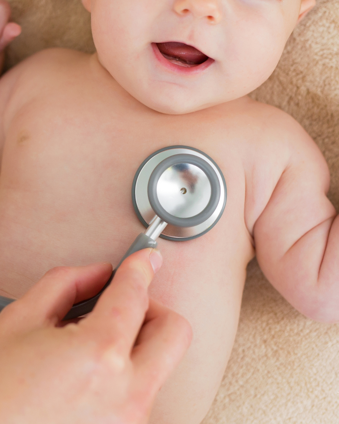 Pediatric doctor examining baby’s heartbeat with stethoscope during medical check-up. Infant health assessment and pediatric care concept.