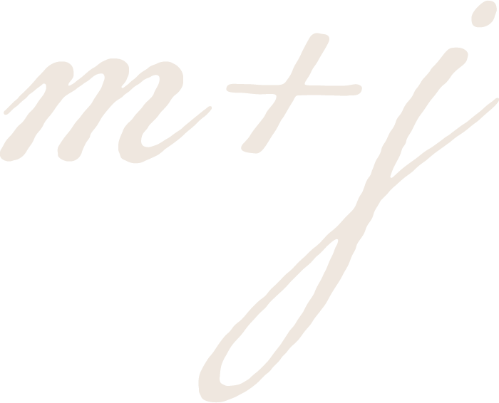 Close-up of stylized handwritten letters 'm + j' on a black background.