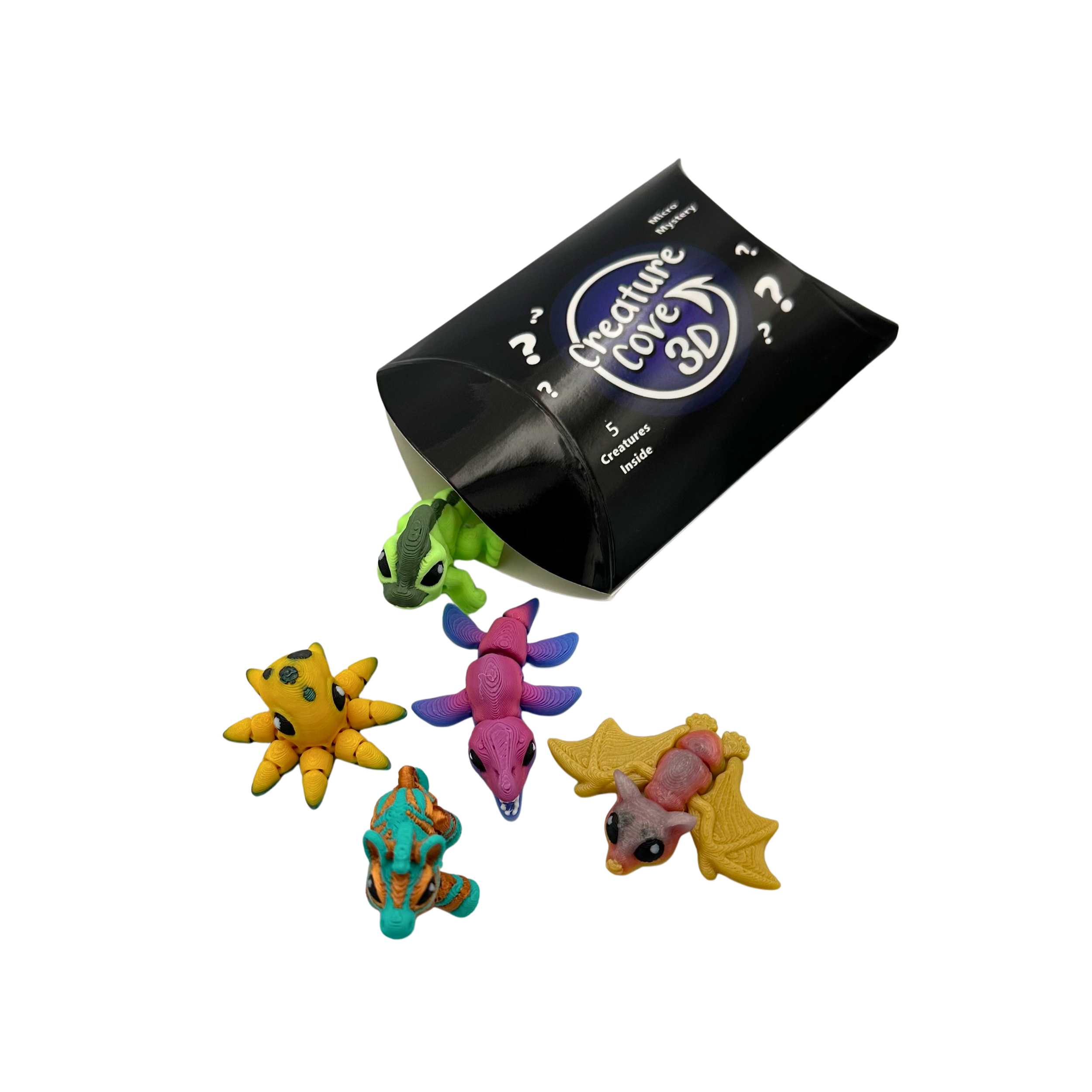 A box labeled 'Creature Cover 3D' tipping over, spilling various colorful toy creatures such as a green dinosaur, a yellow starfish, a pink dragon, a tan and gray rodent, a blue striped animal, and a yellow bat on a black background.
