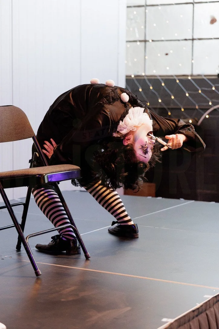 Bambi Karloff as Babette the Clown swallowing a dagger at Moisture Festival's open mic August 2025.