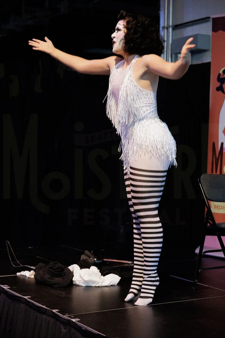 Bambi Karloff as Babette the Clown working the audience at Moisture Festival's open mic, August 2025.