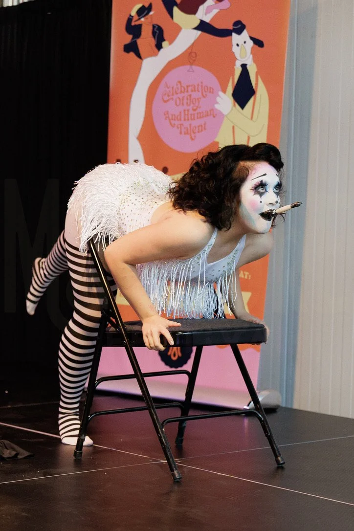 Bambi Karloff as Babette the Clown swallowing a dagger at Moisture Festival's open mic, August 2025.