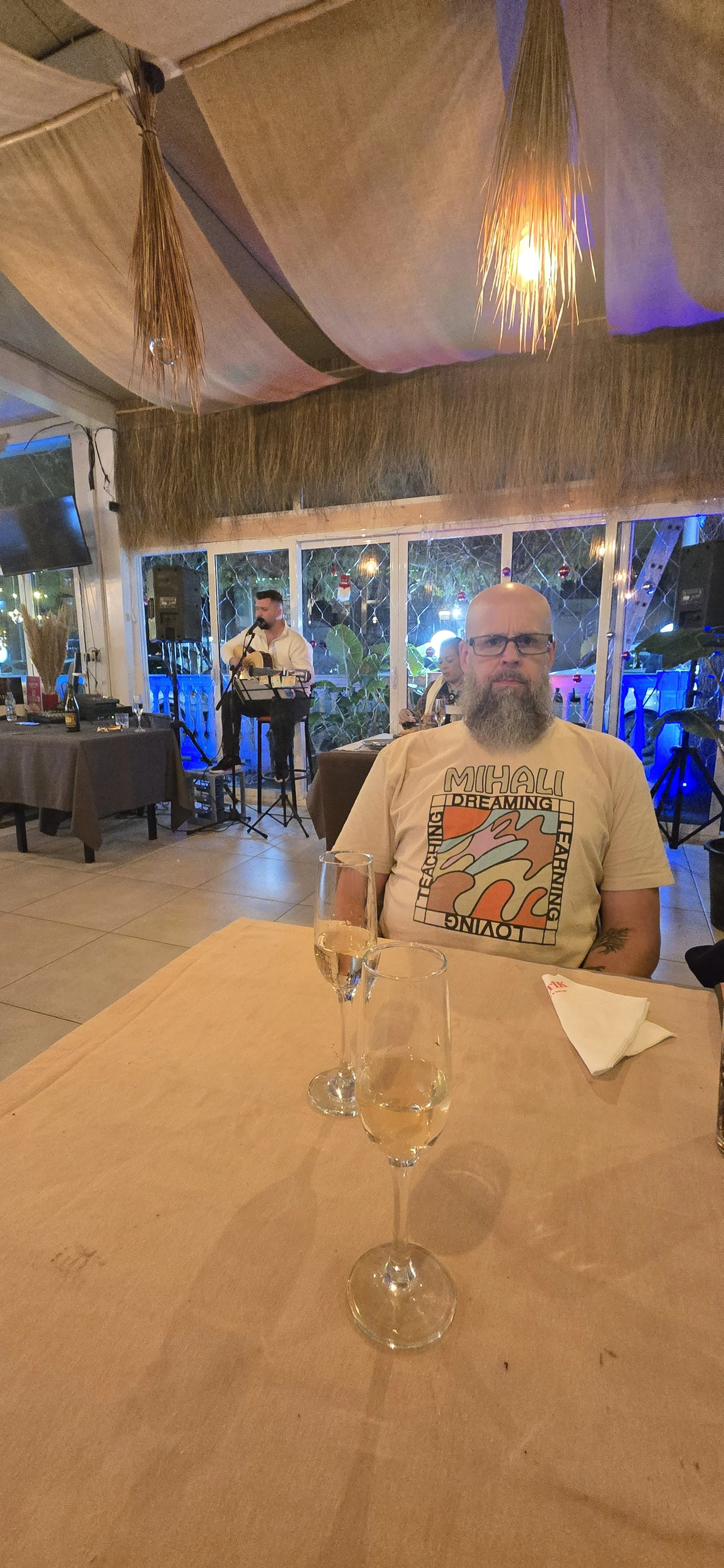 live music Albanian vocalist and a patron enjoying the music with a glass of local sparkling wine