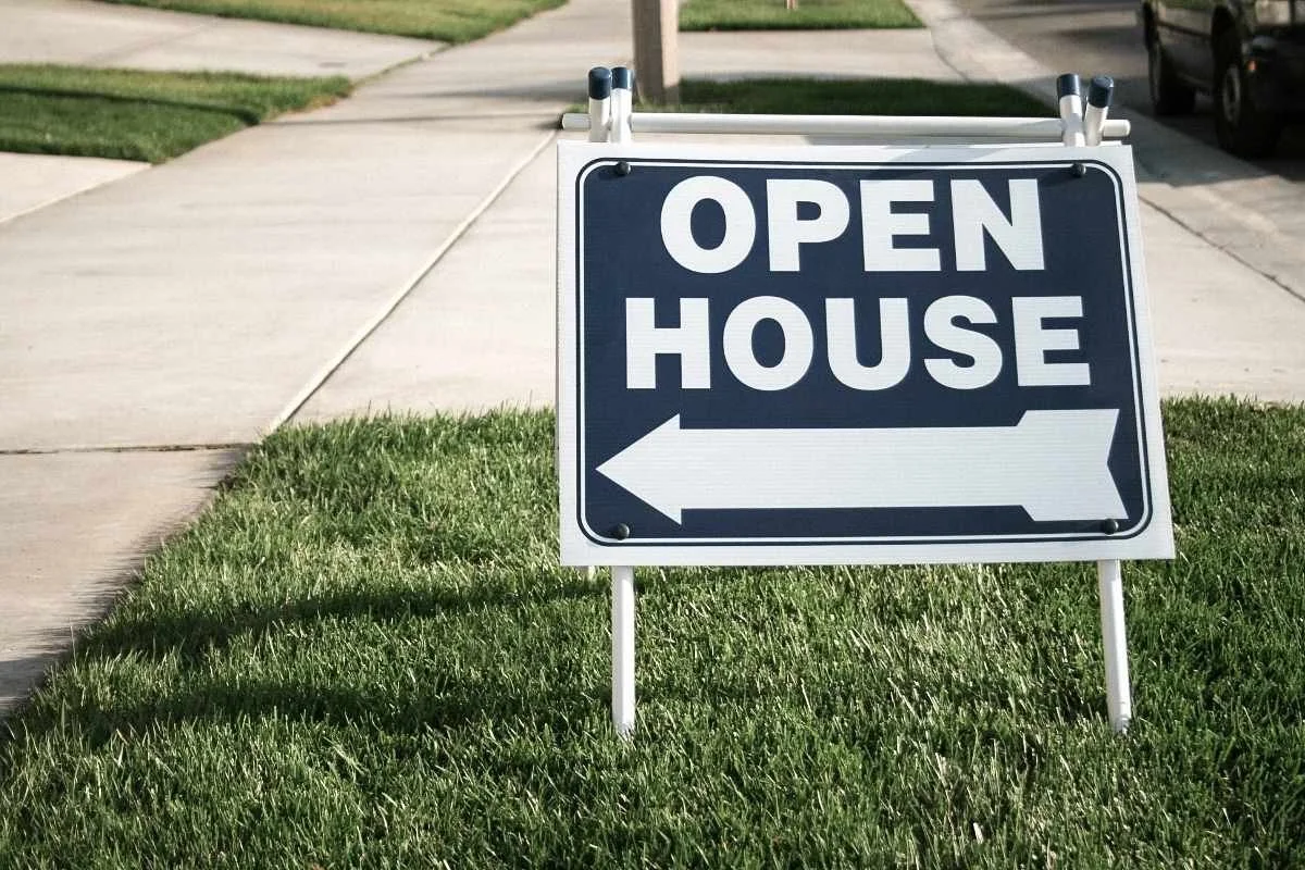 Open house sign in front of a well-maintained concrete driveway in South Florida, highlighting curb appeal before selling.
