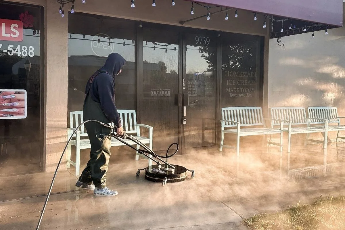 Pressure washing concrete sidewalk outside Let’s Chill Homemade Ice Cream in Coral Springs