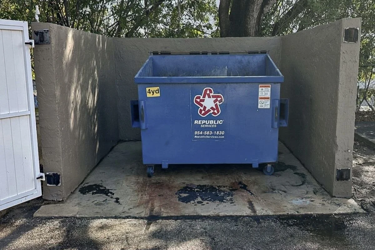 Dumpster pad with staining and buildup at a managed commercial property in Broward County.